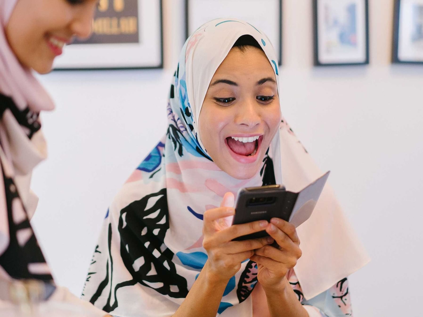A lady on her phone laughing at Hotel Maya KL