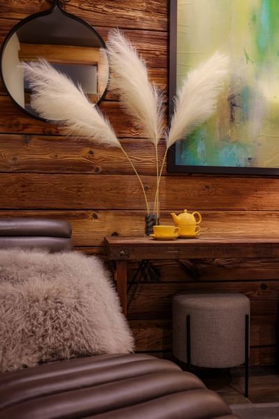 Cozy interior corner with fluffy pampas grass, yellow tea set and abstract art in Inn at Willow Grove