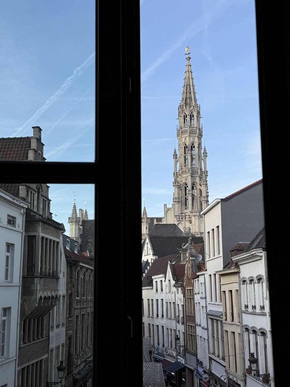 Panoramic view of the historic city tower by a window frame in Junior Suite Privilege View at Warwick Grand Place Brussels