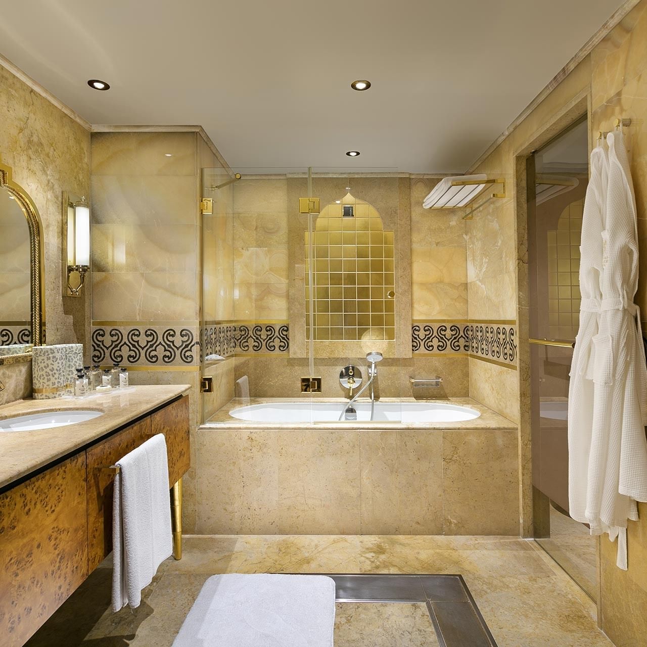 Elegant bathroom with a large bathtub, double vanity, and luxurious decor, including a white robe and towels in Pool Duplex Suite at Titanic Mardan Palace.