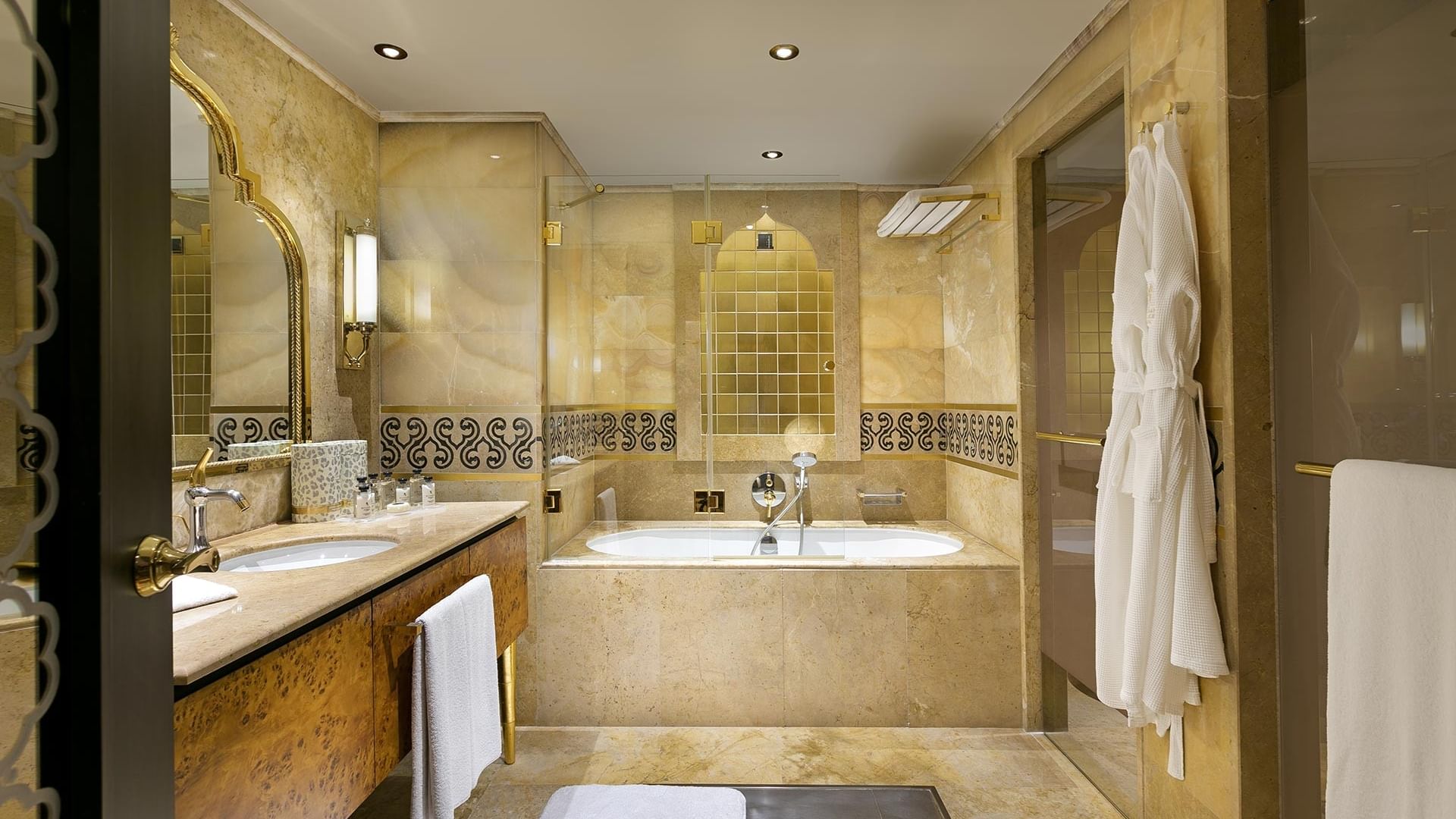 Elegant bathroom with a large bathtub, double vanity, and luxurious decor, including a white robe and towels in Pool Duplex Suite at Titanic Mardan Palace.