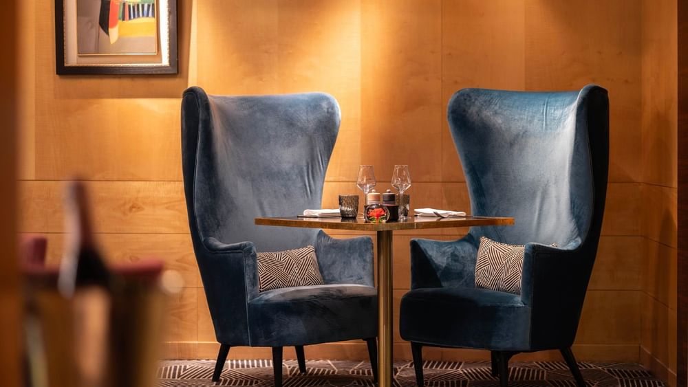 Two blue velvet chairs around a round table at Restaurant Le W in Paris at Warwick Champs-Elysees.