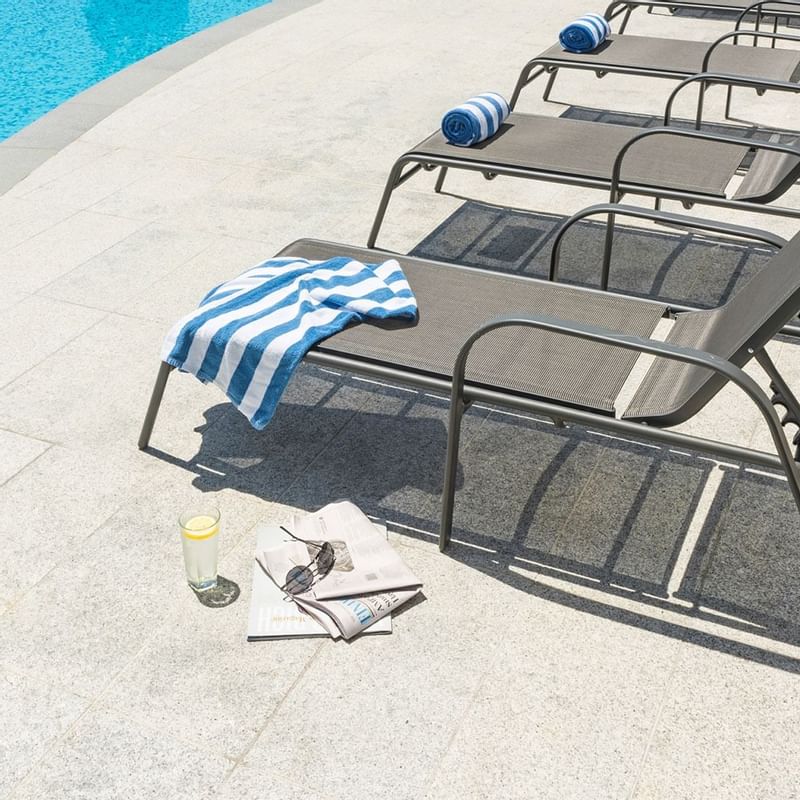 Towels on sunbeds near the pool at Crown Promenade Perth