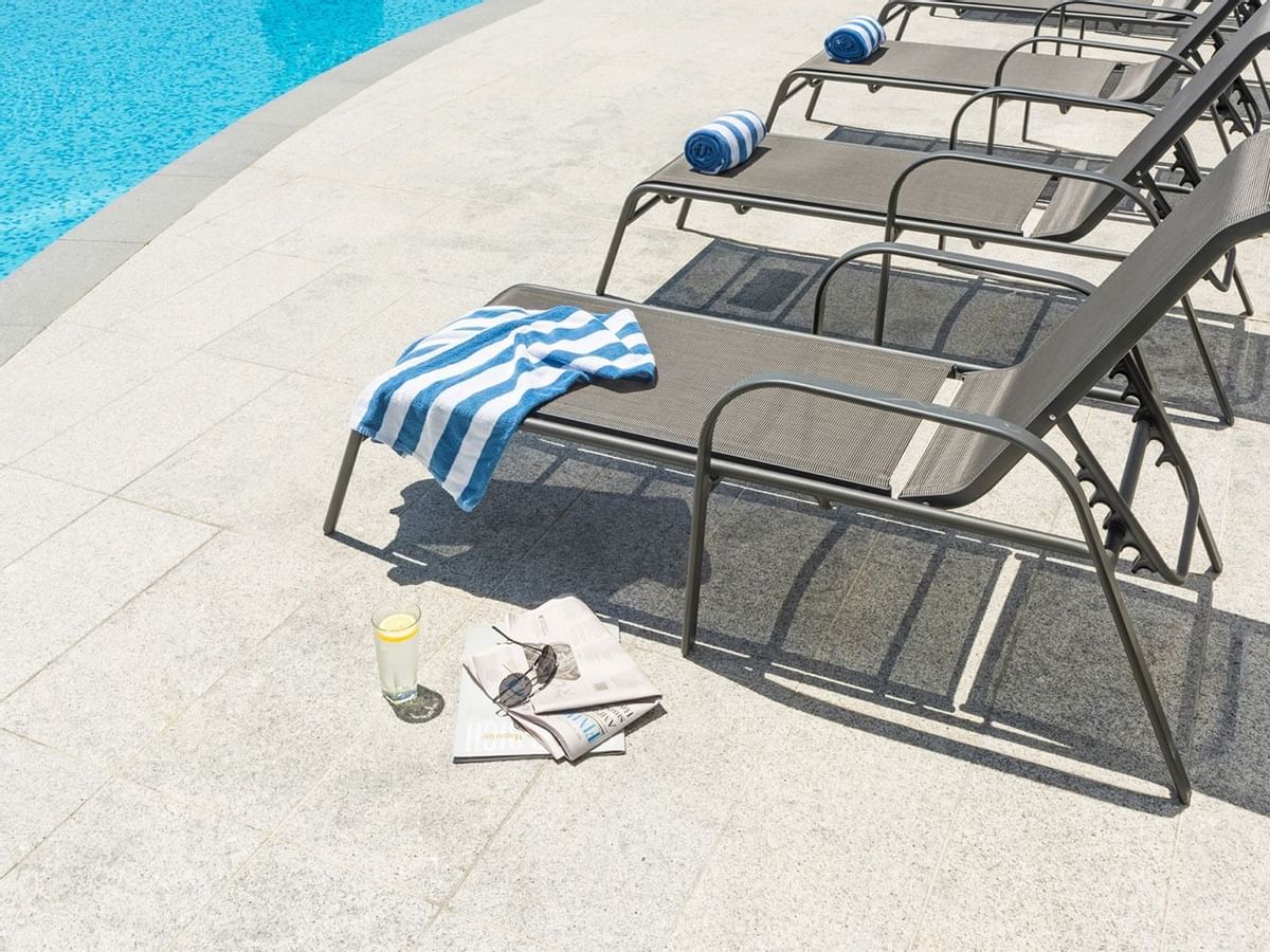 Towels on sunbeds near the pool at Crown Promenade Perth