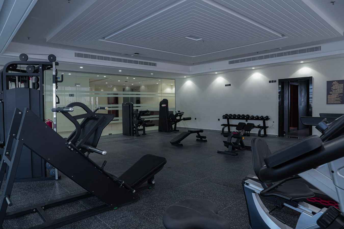 Modern gym with various exercise machines and weights arranged on the floor at Warwick Hotel Spa Jeddah