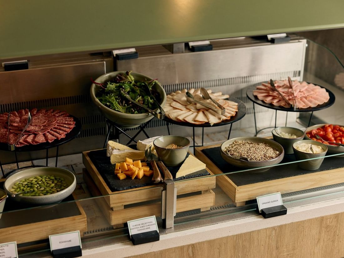 Buffet spread with salami, greens, cheeses, ham, tomatoes, and toppings at Pullman East Melbourne