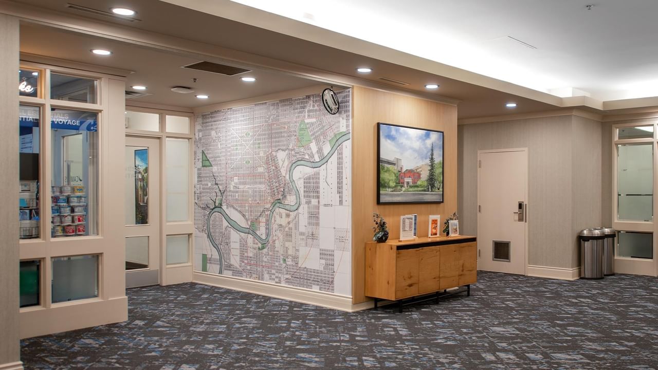 Hotel lobby with a reception area, wall artwork and seating.