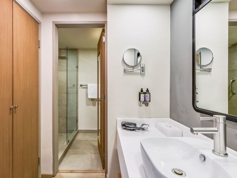 Vanity area with wall mirror, cupboard and amenities in Prime Suite at Fiesta Inn