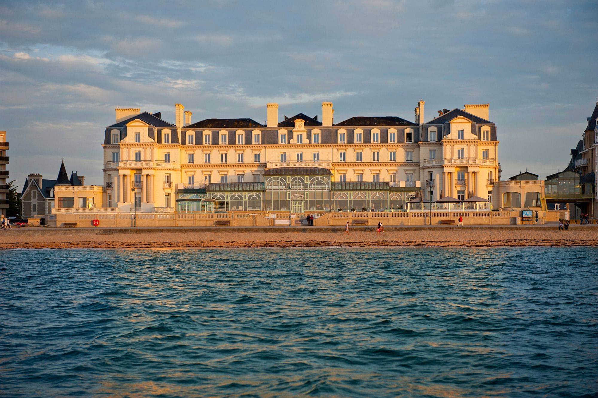 The grand historic facade of a beachfront hotel viewed at Le Grand Hôtel des Thermes