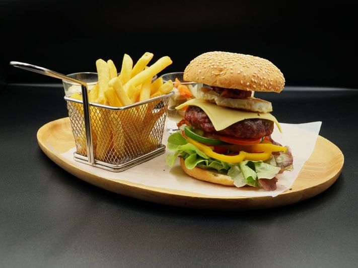 A burger served with fries at Maitria Hotels & Residences