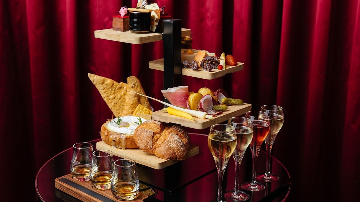 Elegant charcuterie and cheese tiers with crackers & glasses in La Vie Champagne Lounge at Crown Hotels