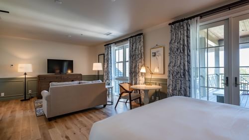 Lounge area with a TV by the bed in Junior Golf Suite at Camp Creek Inn