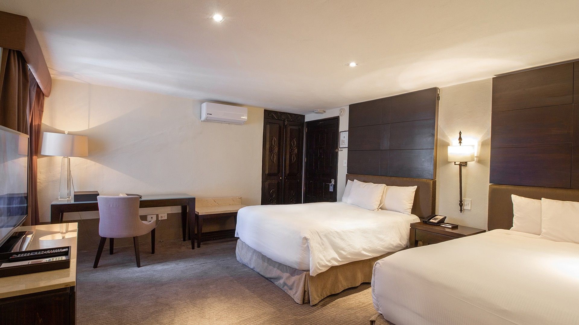 Double Grand Class Suite with two white beds, dark wood accents, and a classic writing desk area at Quinta Real Puebla