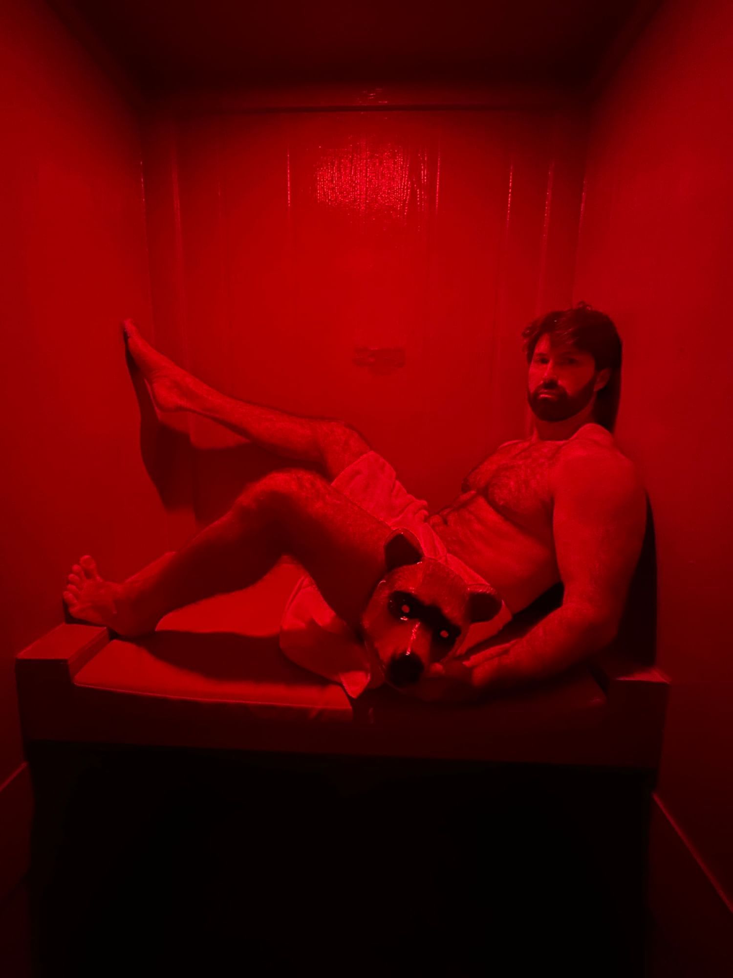 A man relaxing in a red-lit sauna