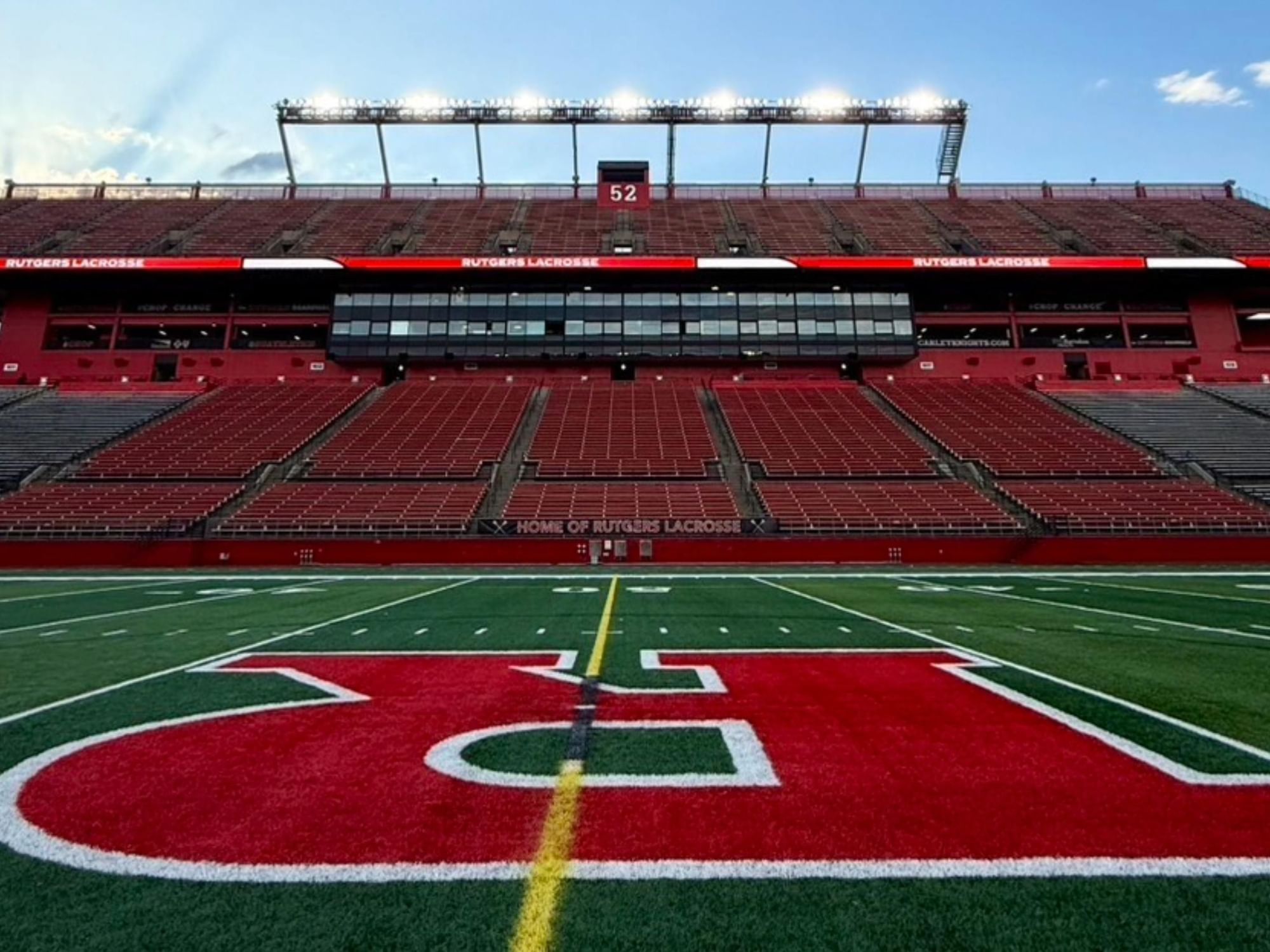Rutgers University SHI Stadium featuring rows of red seats, green field, and the iconic R logo near Garden Executive Hotel