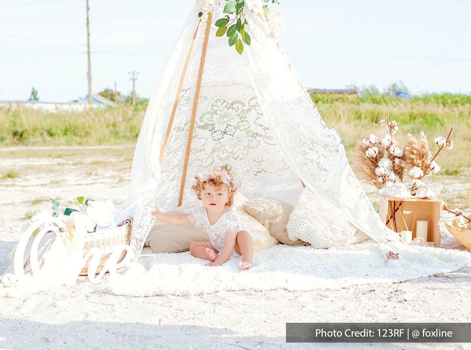 Baby at the beach with pretty white shawl