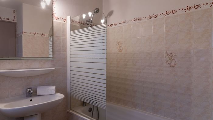 Bathroom bathtub & vanity area in a room at Hotel du Parc