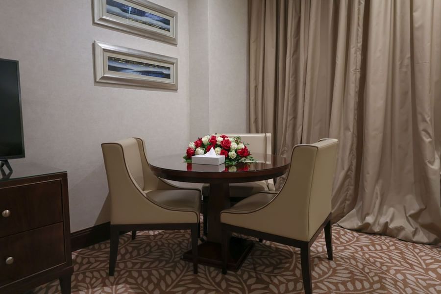 Executive suite dining table for three featuring a beautiful red and white rose centerpiece at Saja by Warwick Makkah