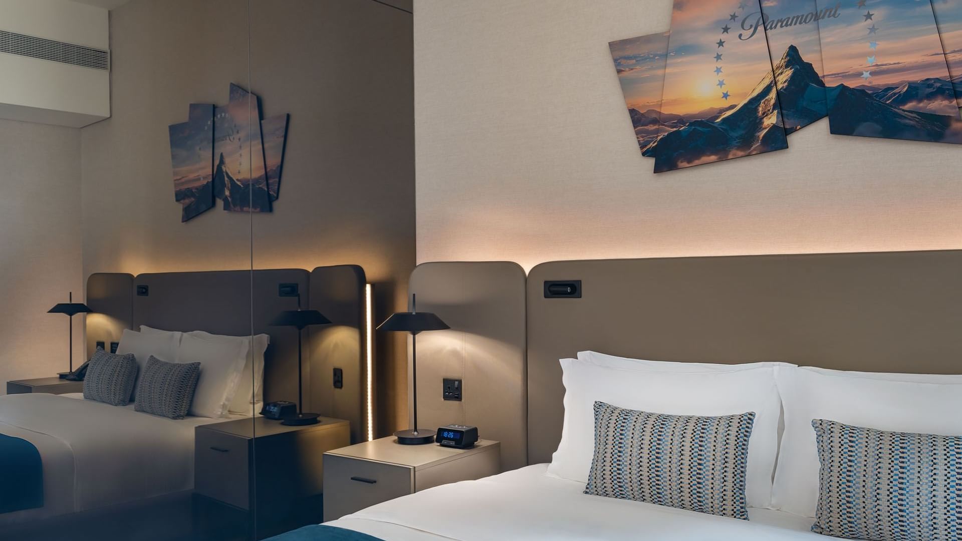 Nightstand between bed and mirror with wall-mounted Paramount logo in A-list Suite at Paramount Hotel Midtown