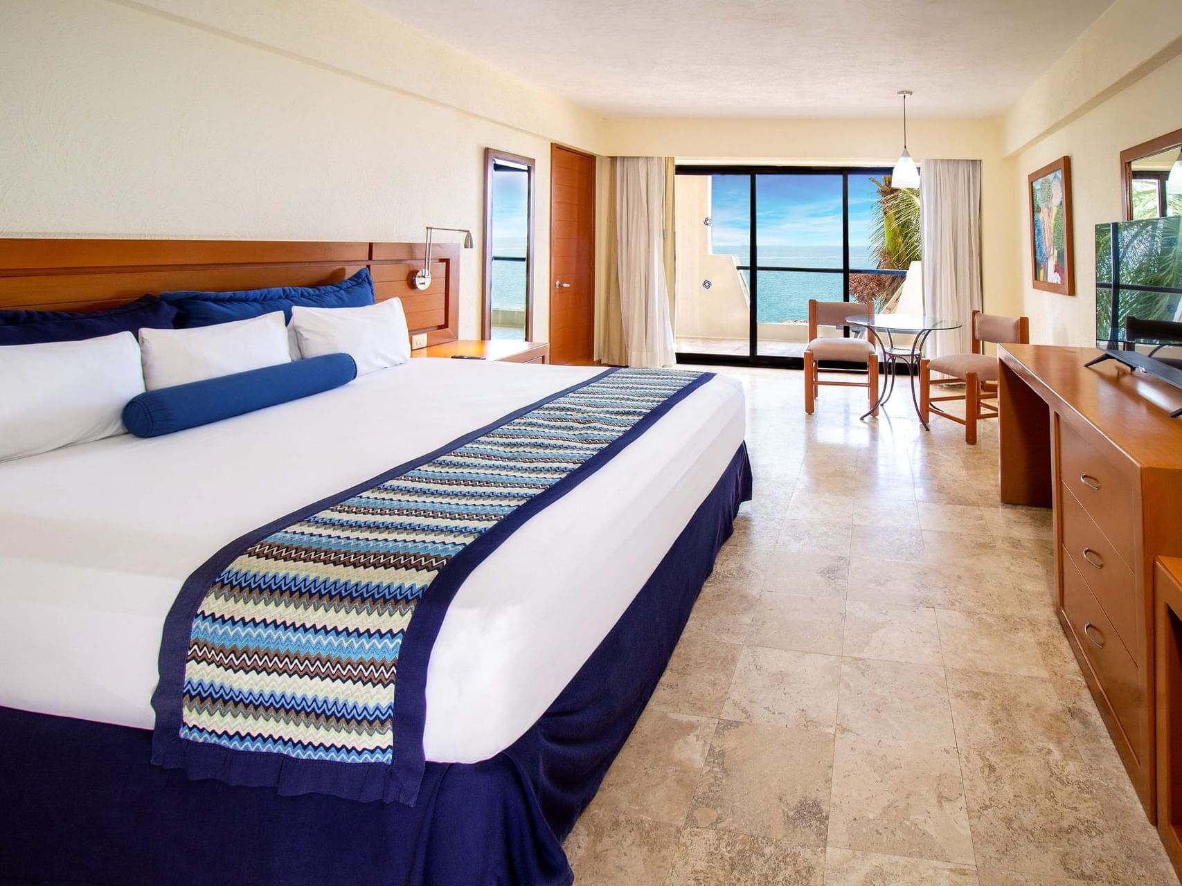 Tv y área de estar junto a la cama en la Suite de 1 habitación con vista al mar del Plaza Pelícanos Grand Beach Resort