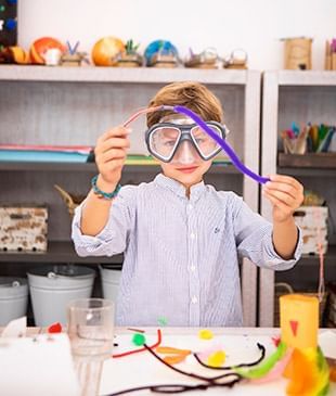 A boy wearing a goggle & doing some craftings at Marbella Club