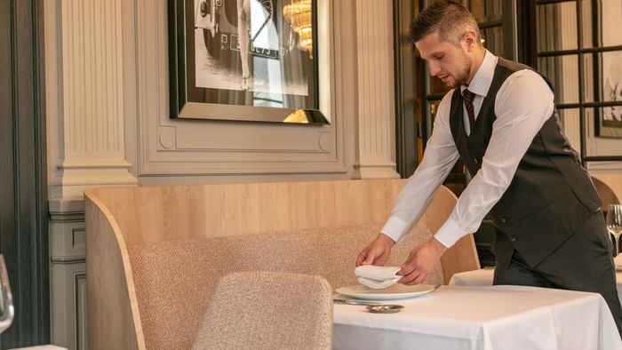 A waiter serving a dish at La Maison Rouge