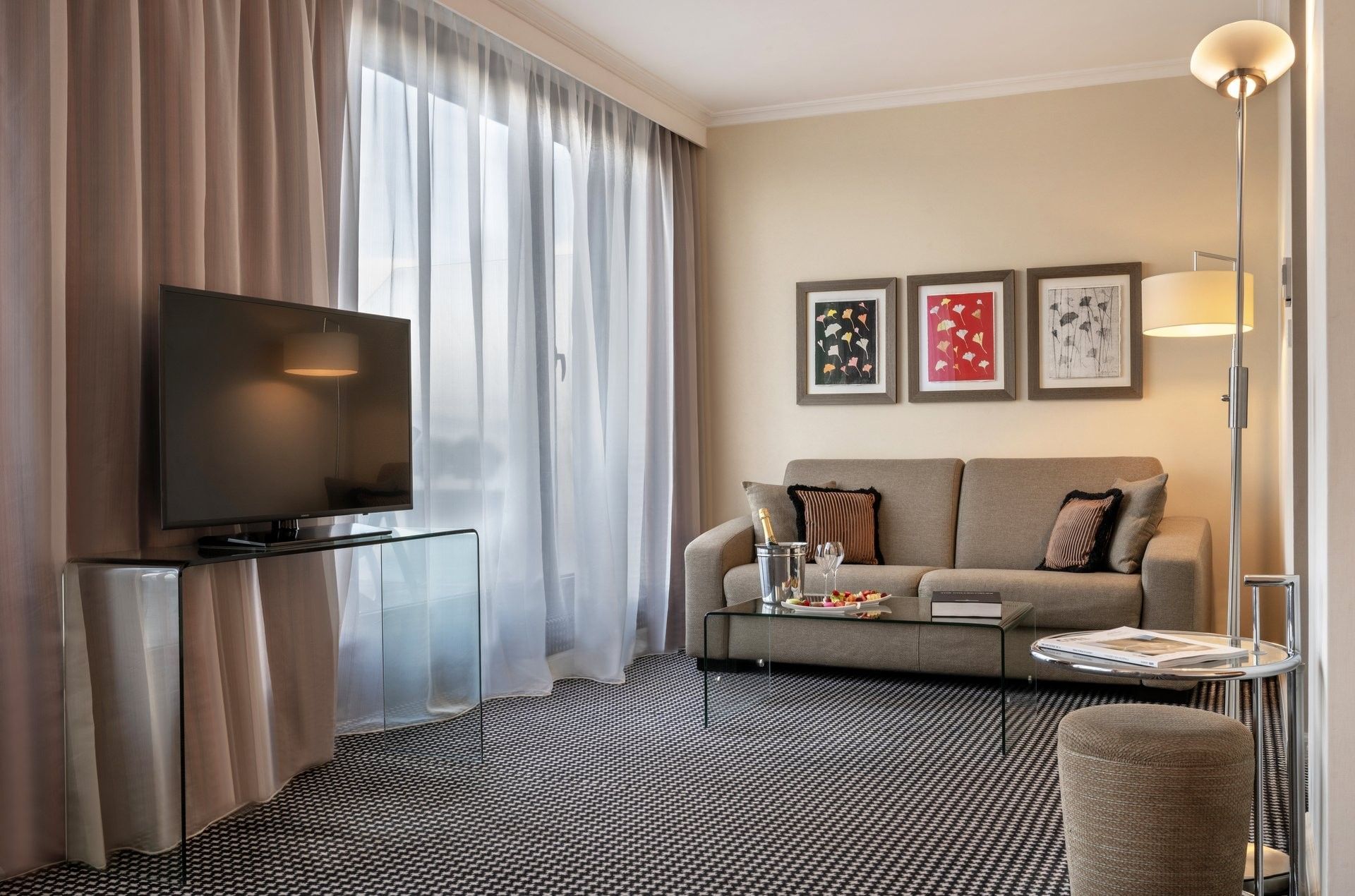 Sofa by framed art under a floor lamp near a glass TV stand in Penthouse Executive Terrace Room at Warwick Geneva
