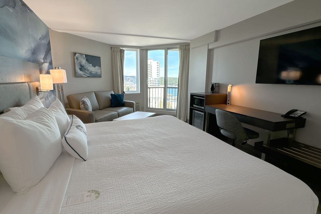 Hotel guestroom with king bed, TV and work desk