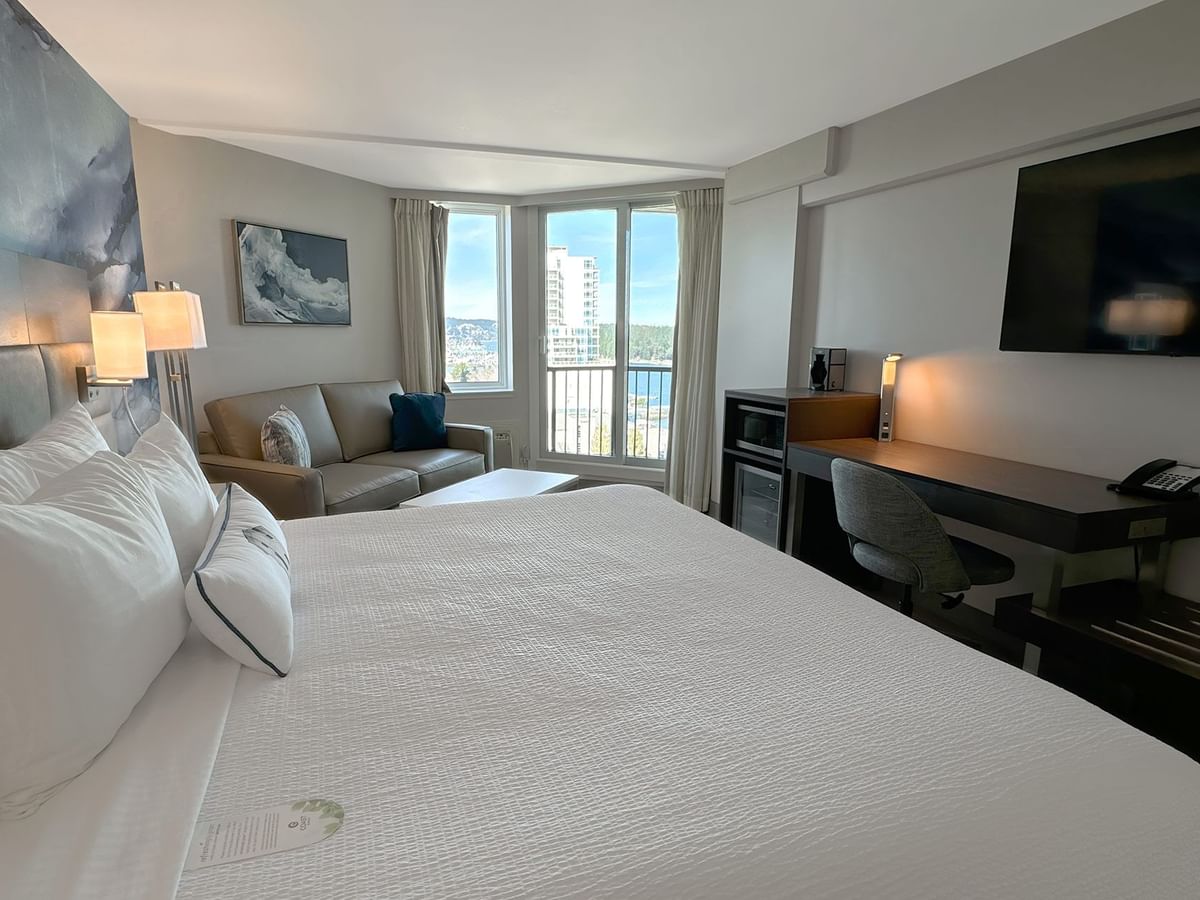 Hotel guestroom with king bed, TV and work desk