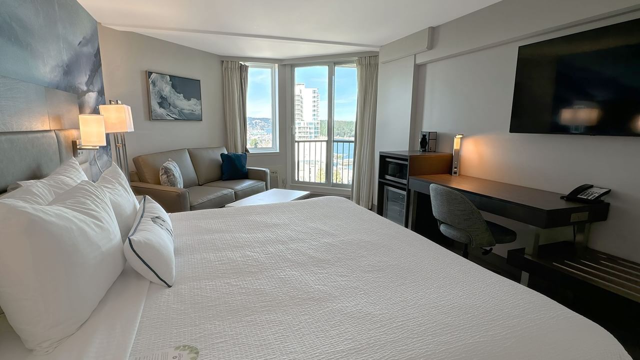 Hotel guestroom with king bed, TV and work desk