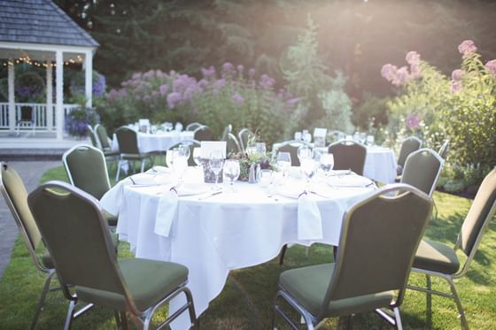 Round tables with chairs on a lawn under soft sun at Oregon Garden Resort, ideal for scenic Silverton wedding venues
