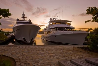 Two large yachts docked at sunset near Barefoot Cay Resort & Marina