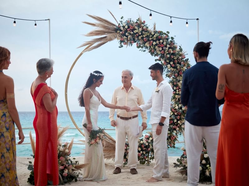 Beach wedding in Cancun with a happy couple exchanging vows at Fiesta Americana