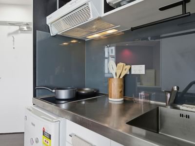 Modern kitchen with stainless steel counter and appliances at UniLodge Auckland City.