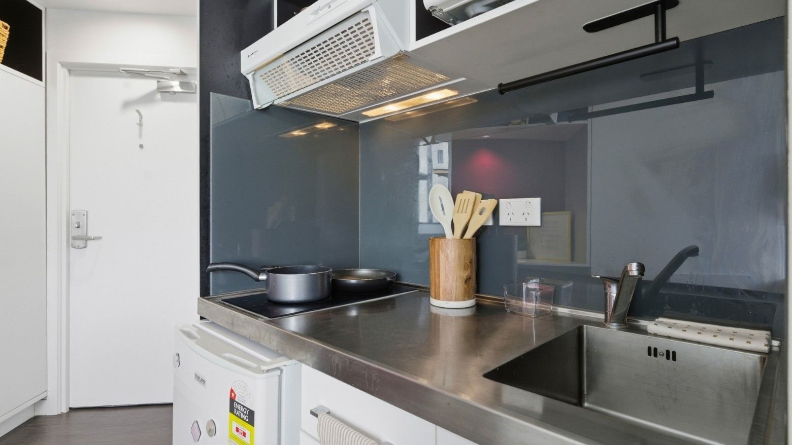 Modern kitchen with stainless steel counter and appliances at UniLodge Auckland City.