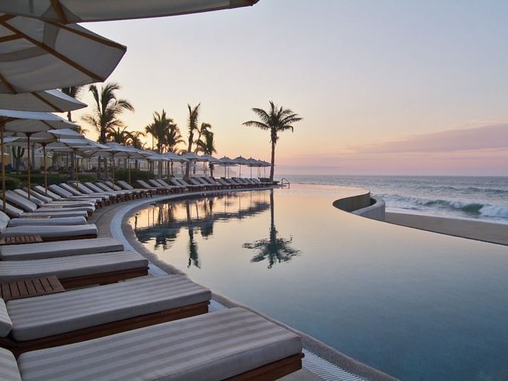 Lounge chairs next to an infinity pool - Marquis Los Cabos