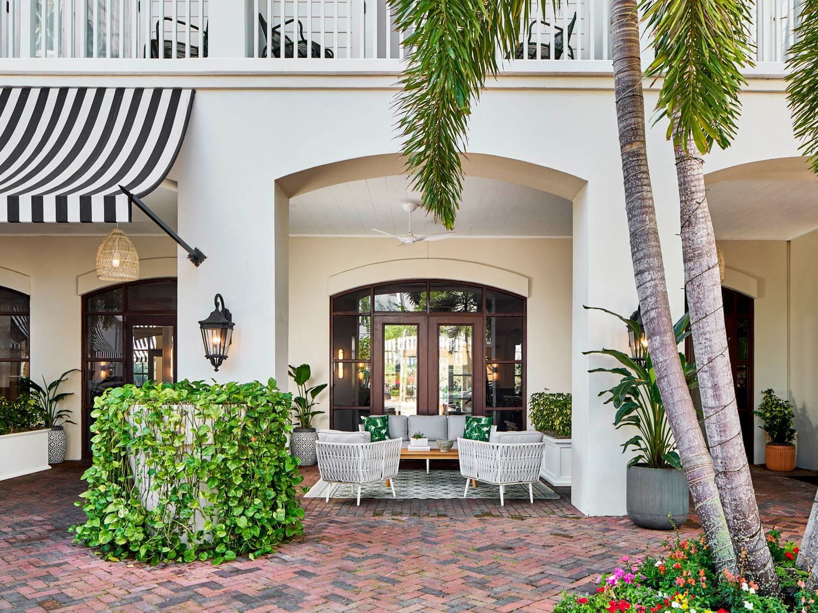 Entrance patio of The Inn at Celebration with two woven chairs under an arched doorway, Celebration FL hotels