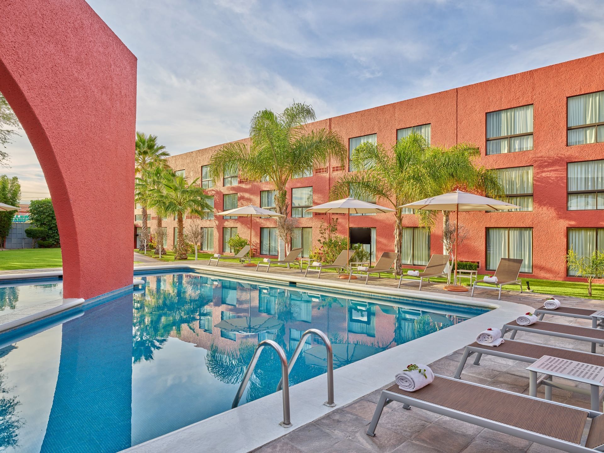 Outdoor swimming pool area with sunbeds at Fiesta Inn