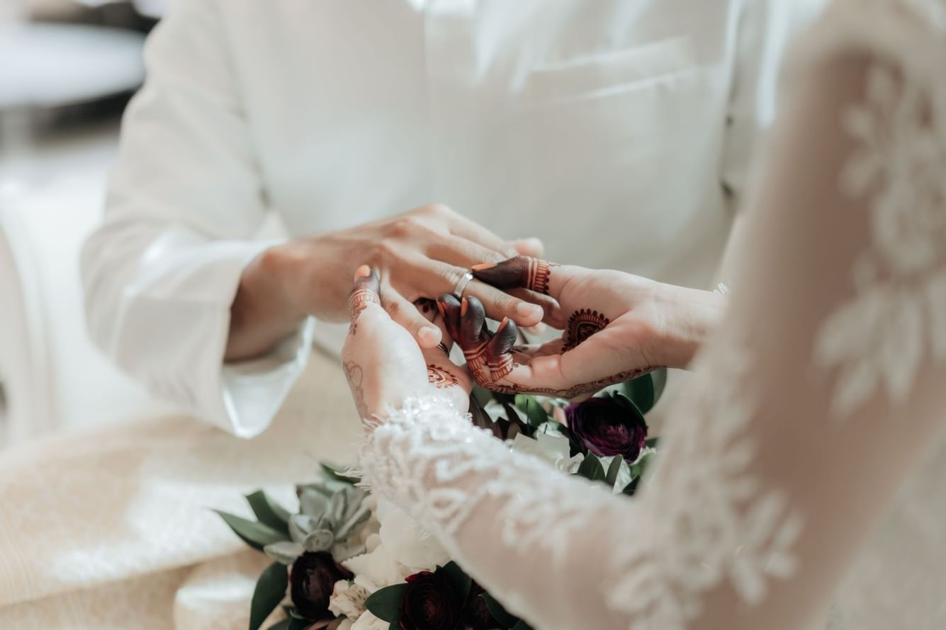 Closeup of a couple exchanging rings at Fullerton Bay Singapore