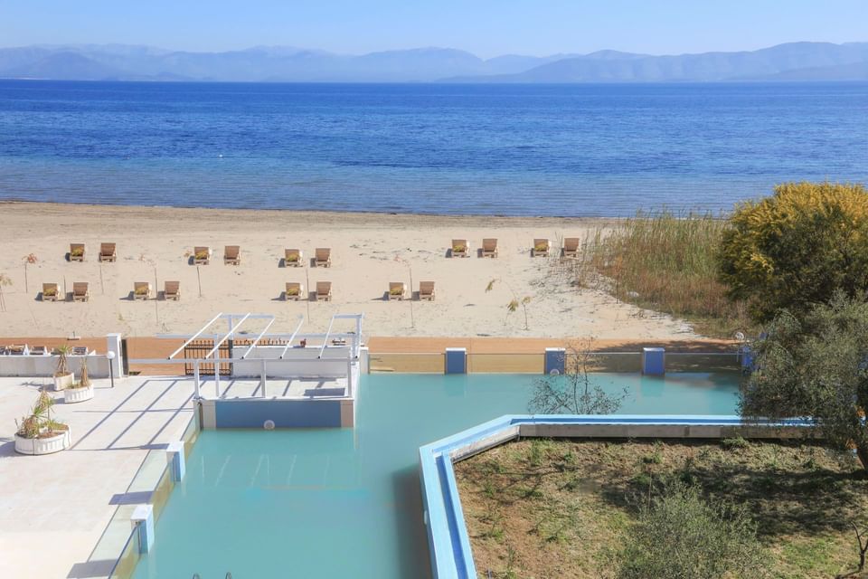 Distant view of pool and beach of Cavomarina beach hotel