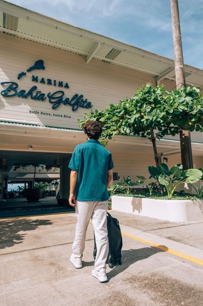 Man entering the hotel of Marina Bahia Golfito with a traveling bag near Amaka Ocean Living Lodge
