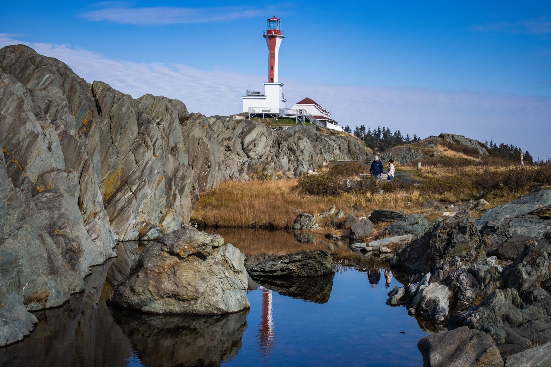 Cape Forchu Lighthouse on a rocky coast under a blue sky near Rodd Grand Yarmouth, one of the best attractions in Yarmouth