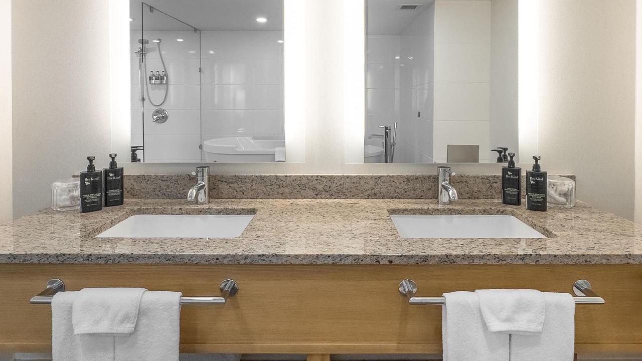 Two sinks with towels and soaps in a hotel bathroom at Coast Chilliwack Hotel by APA.