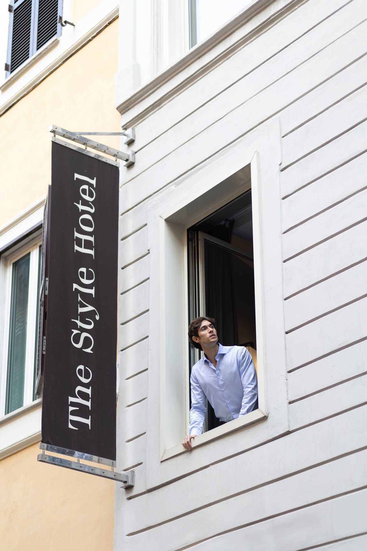 Man peaking through the window by the hotel sign at The Style