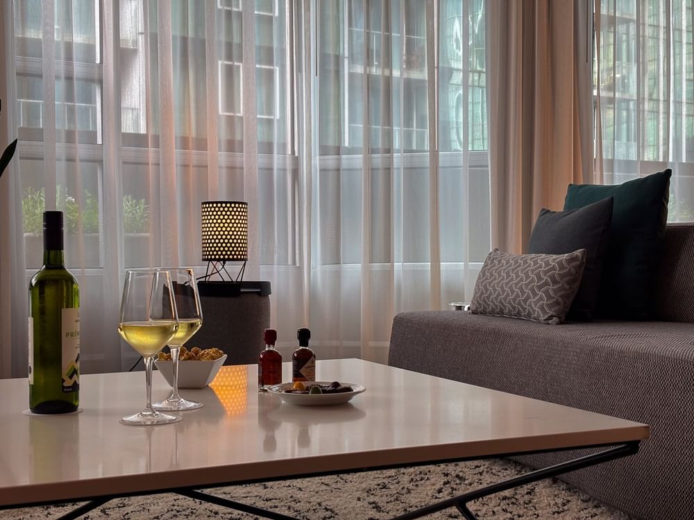 Un espace de vie chaleureux où l'on peut déguster du vin et des amuse-bouches au Penthouse Sainte-Catherine du Warwick Le Crystal Montréal.