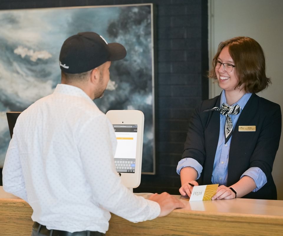 Friendly receptionist assisting a guest at the front desk of Rodd Grand Yarmouth, a top pick among hotels in Yarmouth