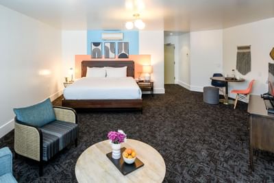Bed and seating area with carpeted floors in King Suite at Beck's Motor Lodge San Francisco
