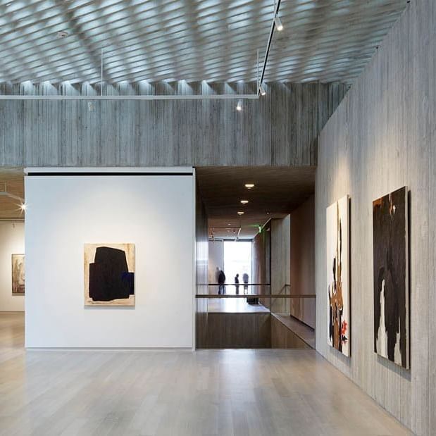 Modern art on wood walls by a polished floor under a lattice ceiling in Clyfford Still Museum near Warwick Denver