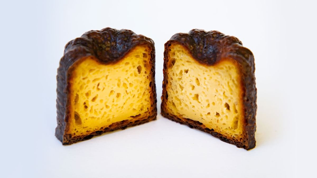 Two halves of a caramelized, custard-filled canelé pastry served in Sacrebleu at Crown Hotels