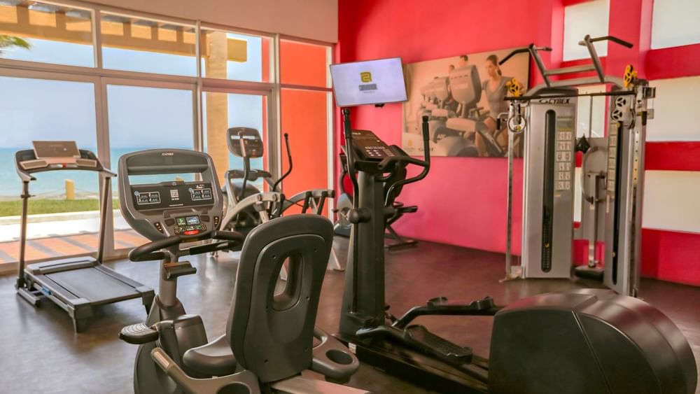 Weight room featuring Cybex equipment and large windows with a view of the beach at Camino Real Veracruz
